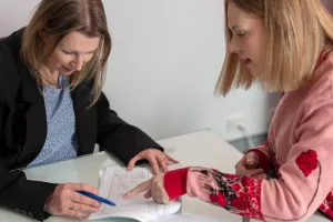 A licensed conveyancer and client inspecting a property contract.